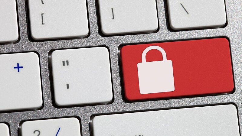 Eine Tastatur mit einer hervorgehobenen Taste mit Schloss-Symbol – symbolisch für eine Fremdsperre., Bild: Tolga TEZCAN / gettyimages